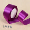 A roll of vibrant purple silk satin ribbon for gift wrapping and craft projects.