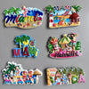 A collection of colorful fridge magnets featuring Miami and Hawaii themes, including palm trees, tropical fruits, and city la