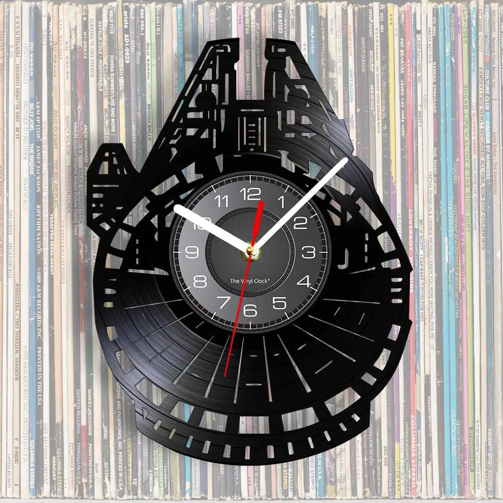 A black wall clock shaped like the Millennium Falcon, featuring a circular face and a vinyl record background.