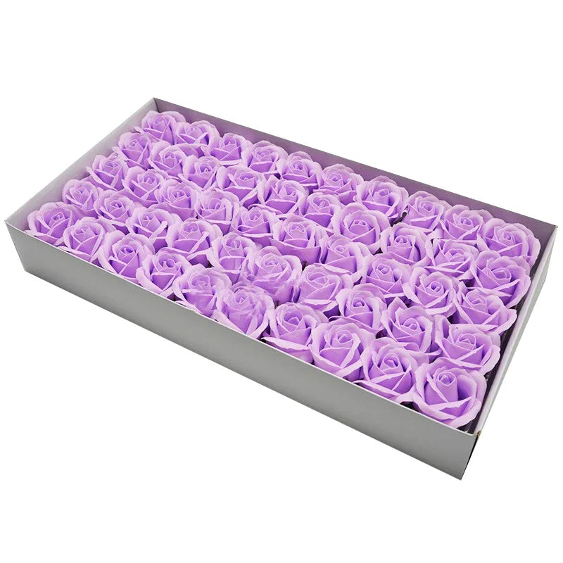 A rectangular box filled with numerous artificial purple rose heads for wedding and party decor.