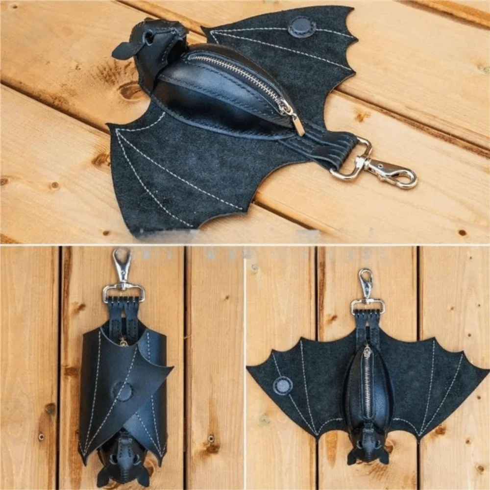 Black leather bat wallet keychain with zipper coin purse resting on a wooden surface.