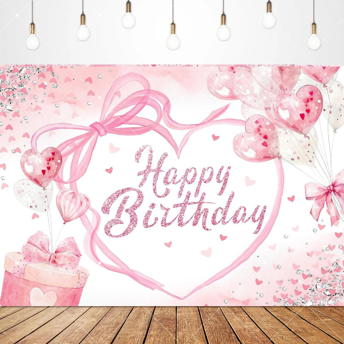 A pink heart-shaped birthday backdrop featuring pink confetti and balloons with a bow.