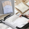 A set of clear zippered storage bags containing folded light-colored shirts and clothing items.