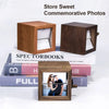 A wooden hand-crank flip photo frame with an LED light displayed on a stack of books.
