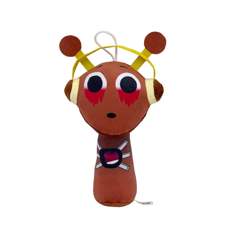 A brown plush toy with yellow ears and a black and white accessory on its body.