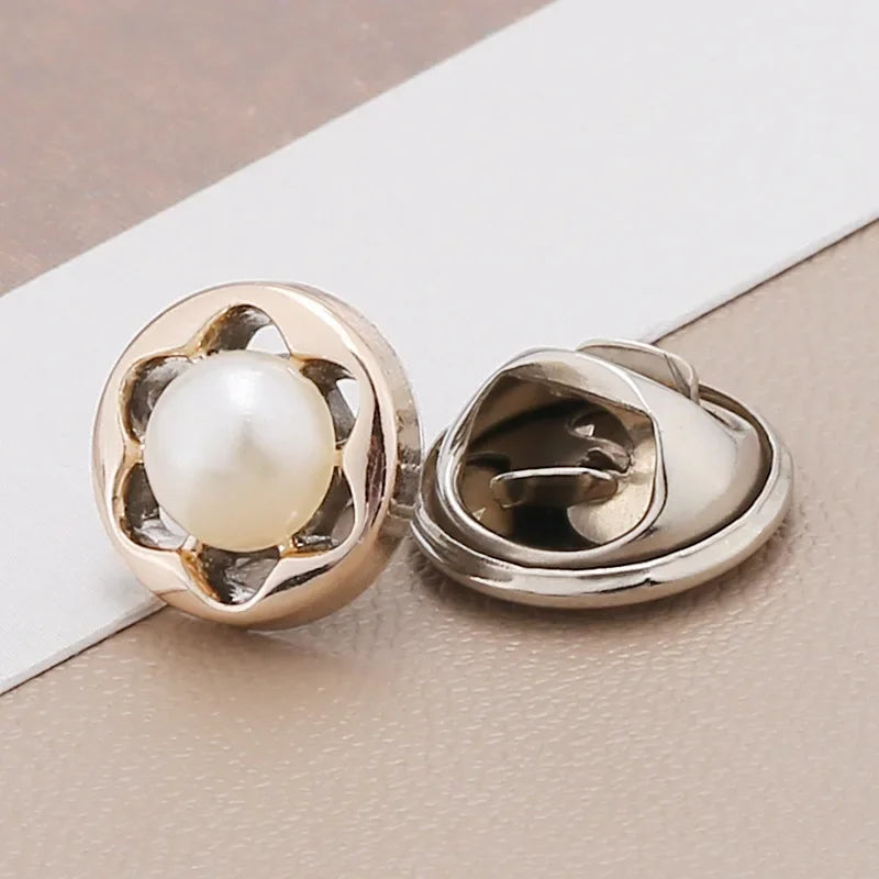 A pair of gold-toned pearl and rhinestone no-sew brooch buttons resting on a white card.