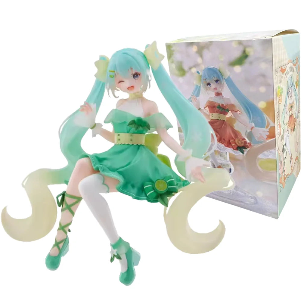 A PVC collectible figurine of Hatsune Miku in a green dress with long light blue hair and wings, displayed in its box.