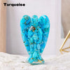 A turquoise crystal guardian angel figurine made of blue stones resting on a white surface.