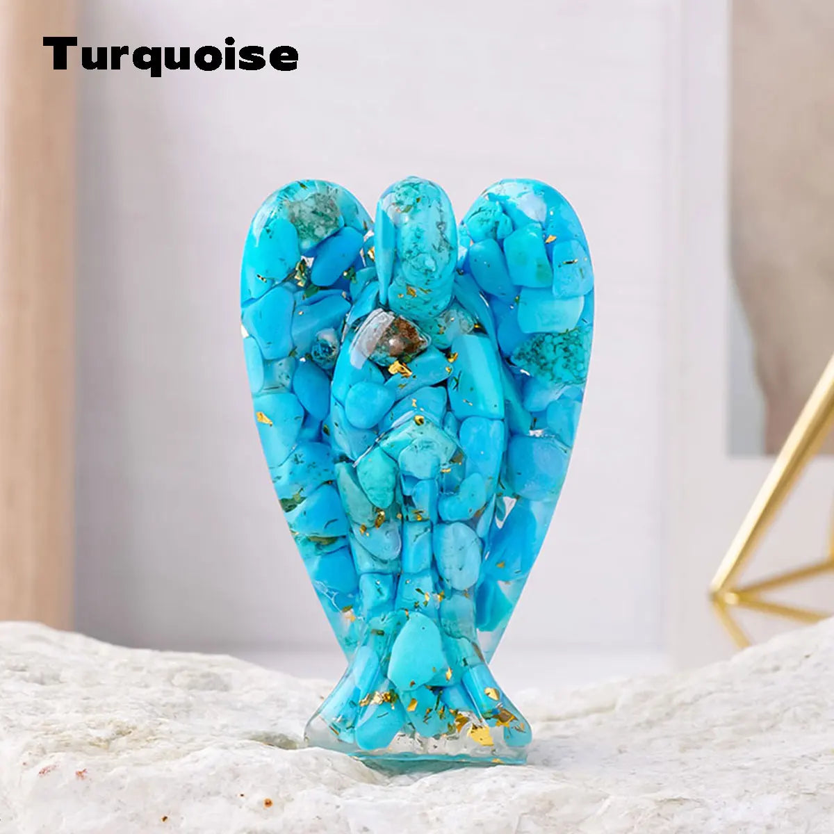 A turquoise crystal guardian angel figurine made of blue stones resting on a white surface.
