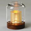 Vintage wooden candle lantern with a glass cover emitting a warm, glowing light.