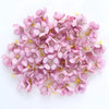 A cluster of pink silk artificial flower heads used for weddings, crafts, and home decor.
