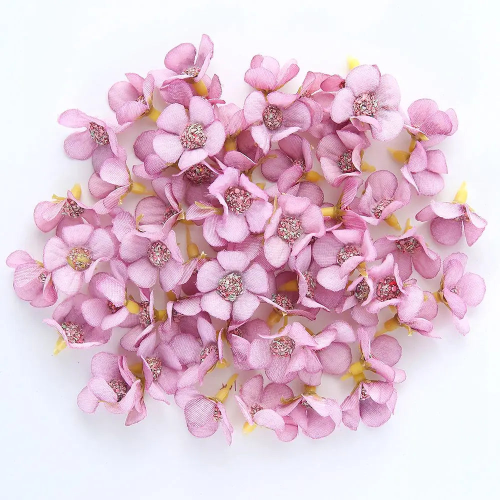 A cluster of pink silk artificial flower heads used for weddings, crafts, and home decor.