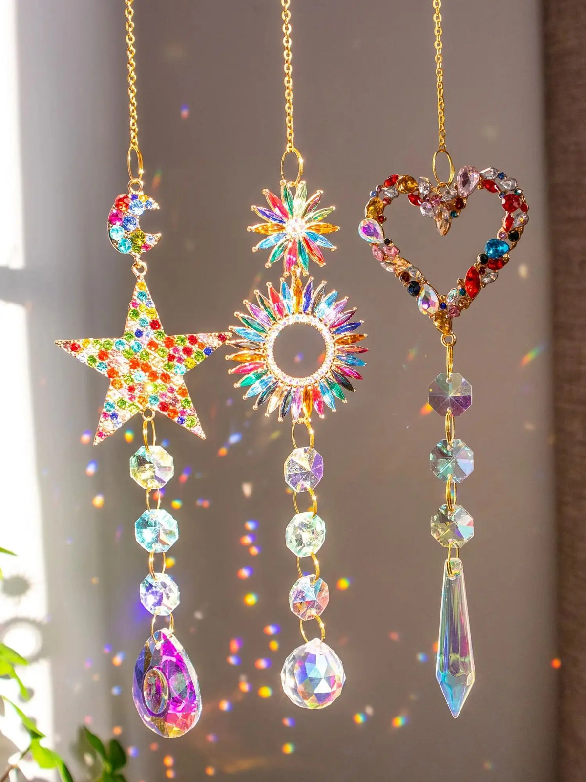 A set of three crystal rainbow sun catchers featuring star, sun circle, and heart designs.
