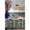 A kitchen backsplash featuring a patterned tile design and wooden bar stools beneath framed artwork.