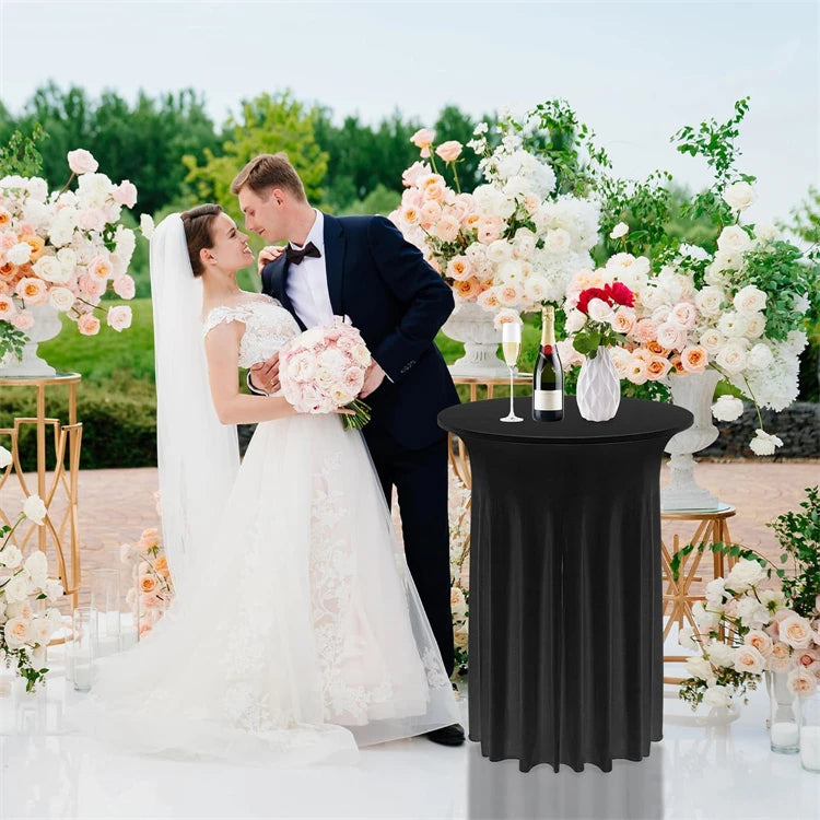 A black stretch spandex cocktail tablecloth draped on a white table, set amidst floral decorations.