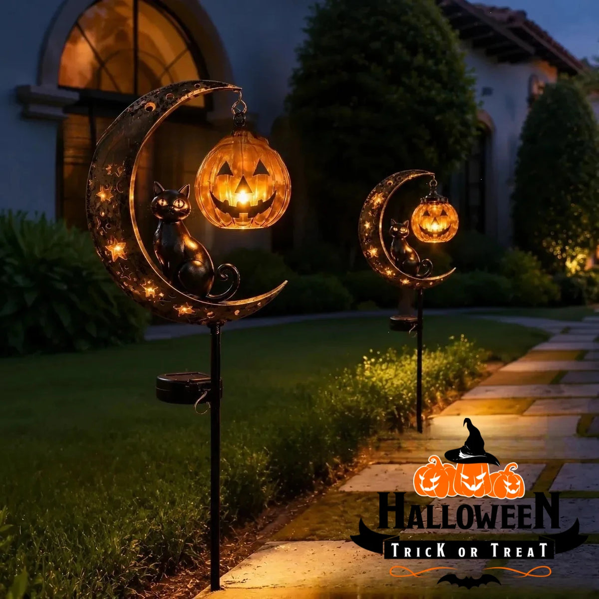 A solar Halloween lantern featuring a crescent moon and black cat silhouette illuminating a pumpkin shape in a garden setting