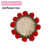 A finished product of a red flower mat made from hand-crocheted fabric flowers.