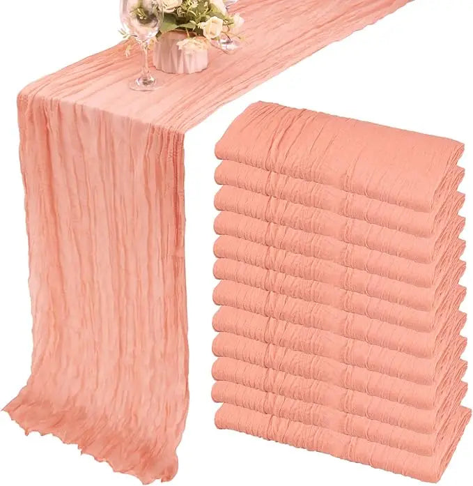 A set of ten terracotta semi-sheer cheesecloth table runners in a dusty rose color.