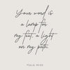 A black script Bible verse on a light gray background, reading Your word is a lamp for my feet, a light on my path. Psalm 119