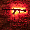 A black gun-shaped LED light is mounted on a red brick wall.