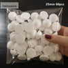 A hand holds a clear plastic bag filled with 60 white polystyrene foam balls, 25mm in diameter.