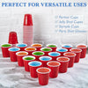 A collection of red disposable shot glasses and sample cups are displayed on a white marble surface.