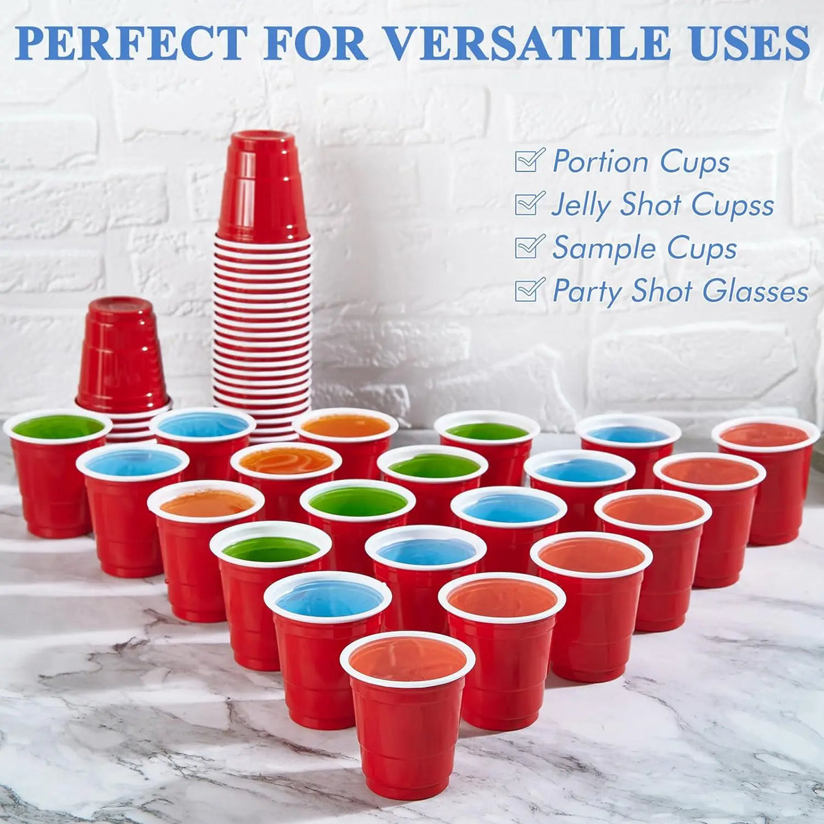 A collection of red disposable shot glasses and sample cups are displayed on a white marble surface.