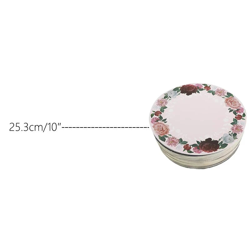A stack of round cardboard cake boards decorated with pink and burgundy floral patterns.