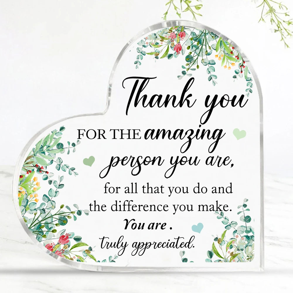 Plaque acrylique en forme de cœur avec verdure florale et écriture élégante remerciant pour son authenticité.