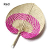 A pink and beige woven hand fan with a peach-shaped design made of bamboo.