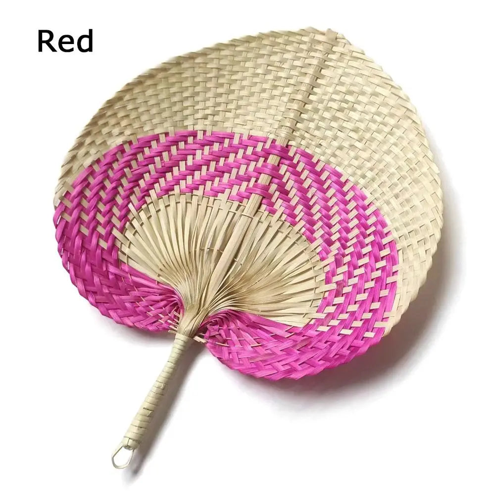 A pink and beige woven hand fan with a peach-shaped design made of bamboo.