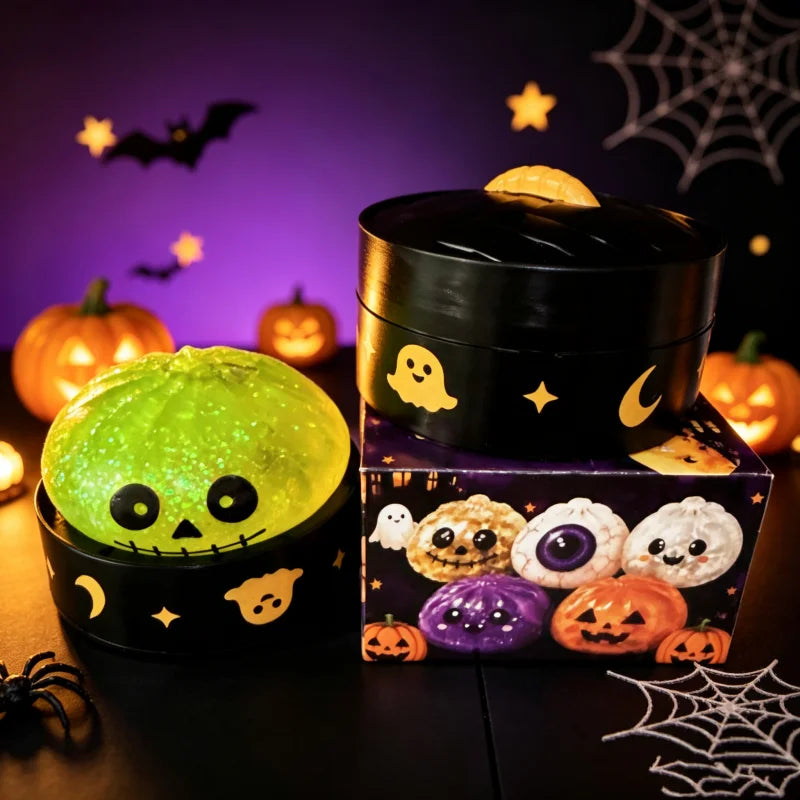 A black sensory squishy blind box containing a glowing green pumpkin-shaped stress relief toy and Halloween-themed items.