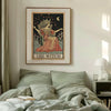 A framed poster depicting a witch figure with a crown and crescent moon on a light background.