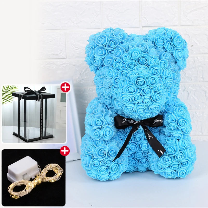 Un ours rose bleu clair et duveteux avec un ruban noir et un accessoire lumineux LED.
