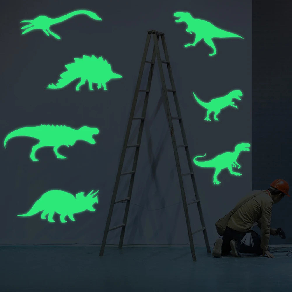 A person is installing glow in the dark dinosaur wall decals on a gray wall using a ladder.