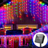 String lights decorate a house facade and roofline with colorful LED icicle lights.