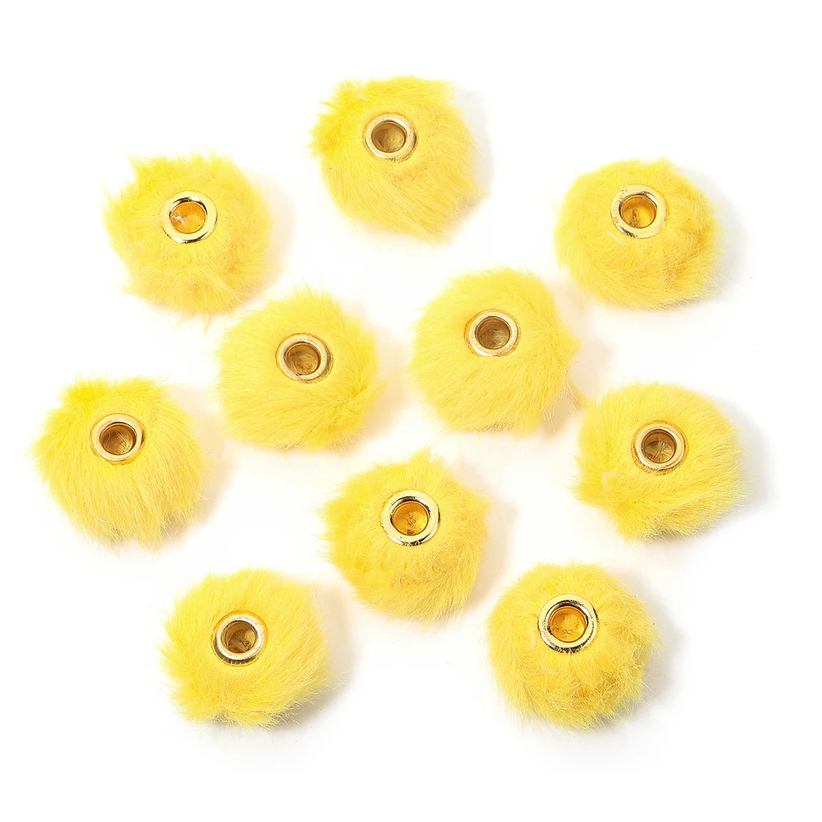Plusieurs boules de peluche jaunes vives avec des perles dorées pour fabriquer des bijoux DIY