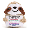 A handmade crochet emotional support donkey desktop ornament with brown and white fur and black features.