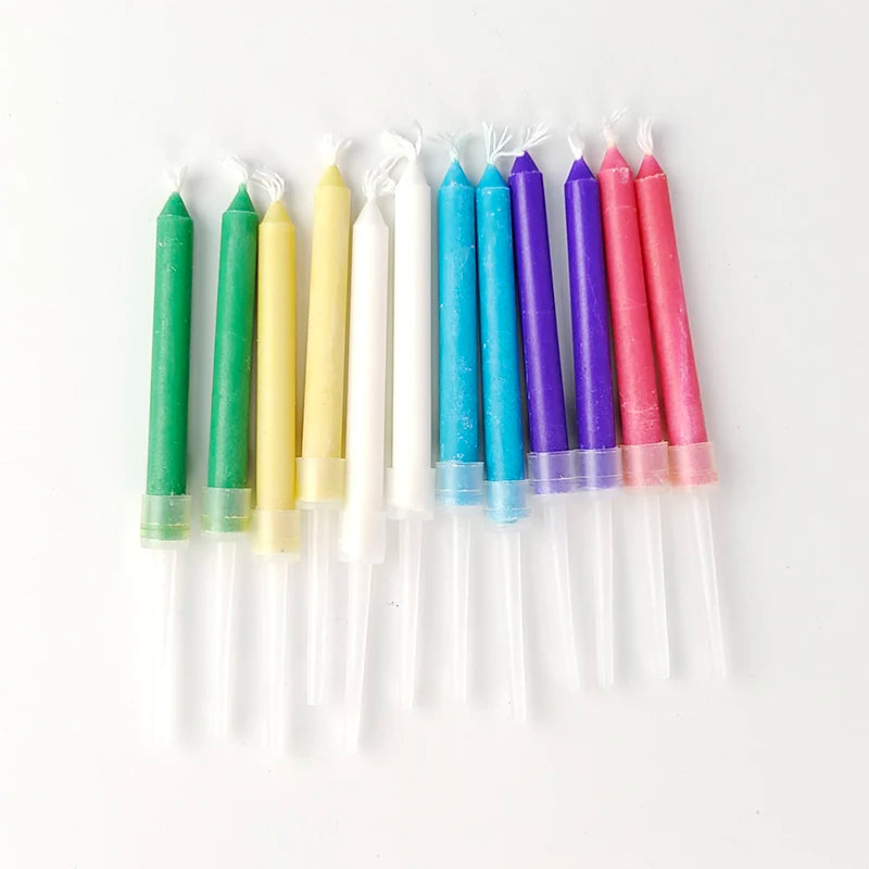 A row of colorful birthday candles in various shades including green, yellow, white, blue, and pink
