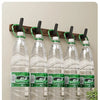 Eight hooks on a wooden coat rack displaying five glass bottles of water.