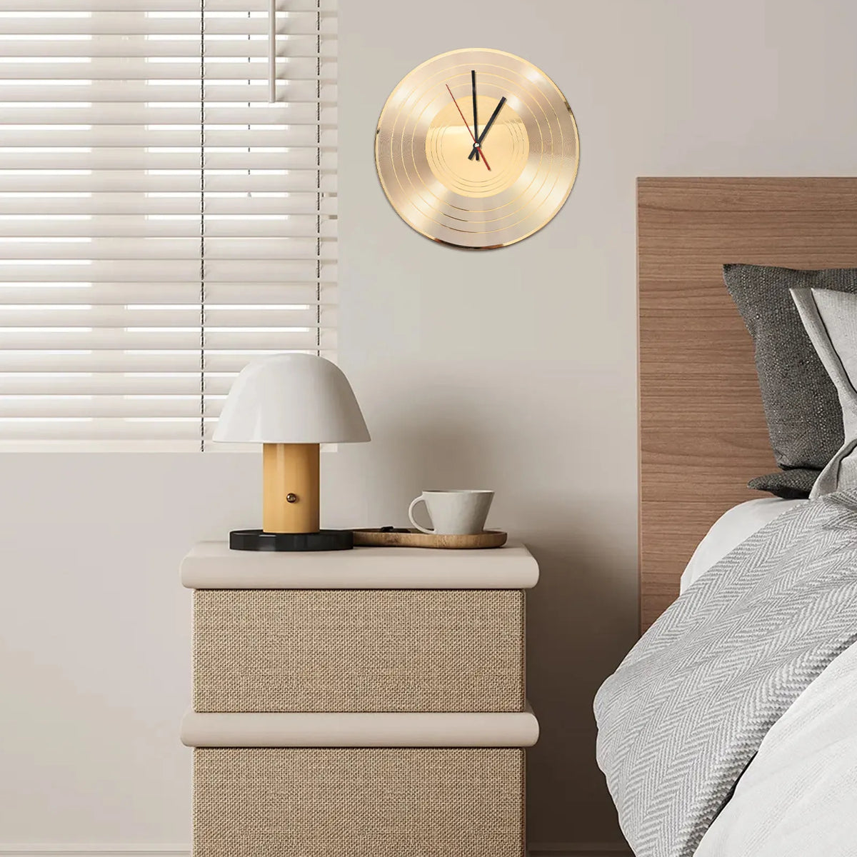 A round gold vinyl record wall clock hangs above a bedside table with a white lamp.
