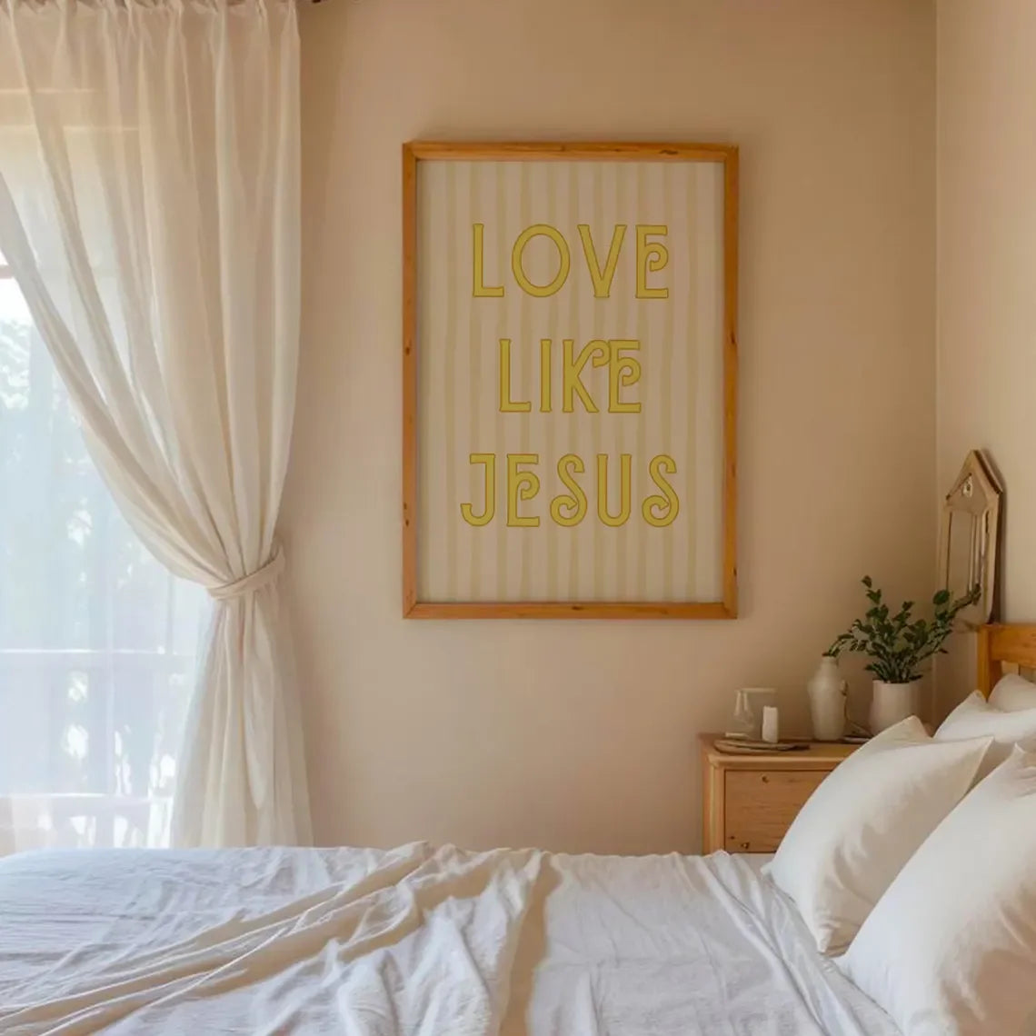 A framed canvas print with the text LOVE LIKE JESUS in gold lettering on a light background hanging on a beige wall.