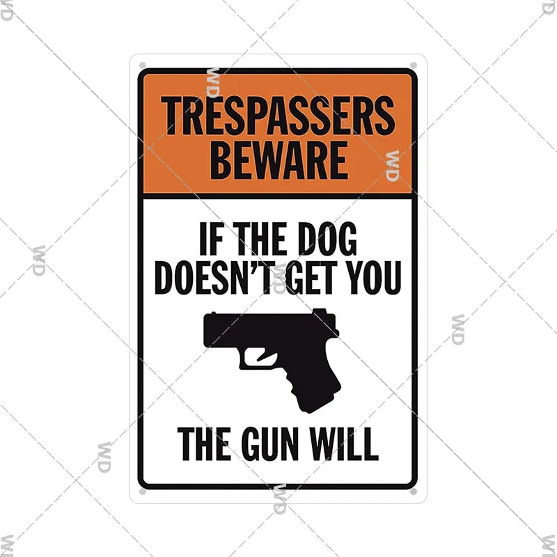 An orange and black warning sign with text that reads Trespassers Beware and a silhouette of a handgun.