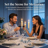 A woman and a man enjoy a romantic dinner setting with wine glasses and candles on a table.