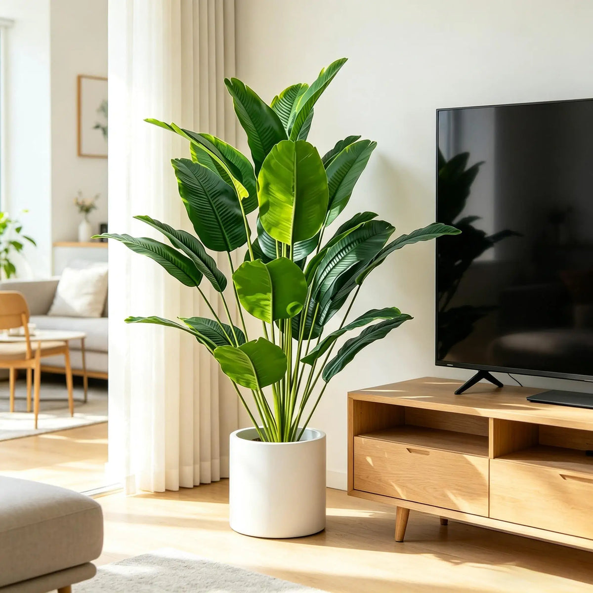 A large artificial Bird of Paradise plant in a white pot sits on a wooden shelf next to a television.