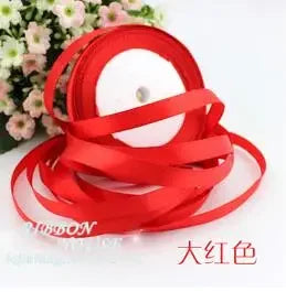 Red silk satin ribbon rolled into a coil on a white background.