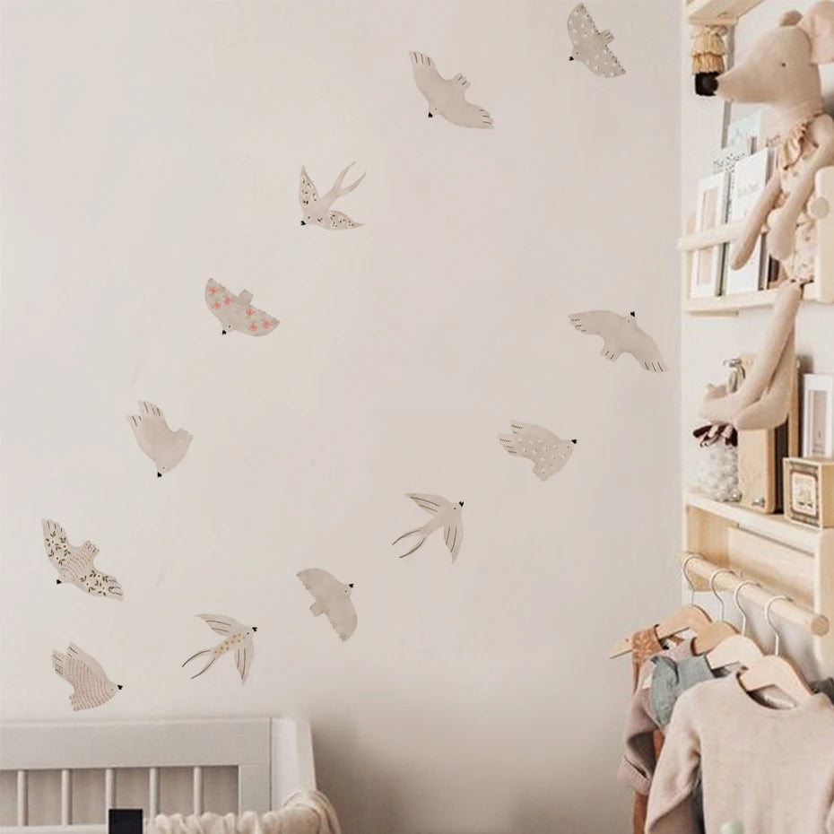 Galeriewand mit verschiedenen abnehmbaren Cartoon-Vogelaufklebern an einer weißen Wand.