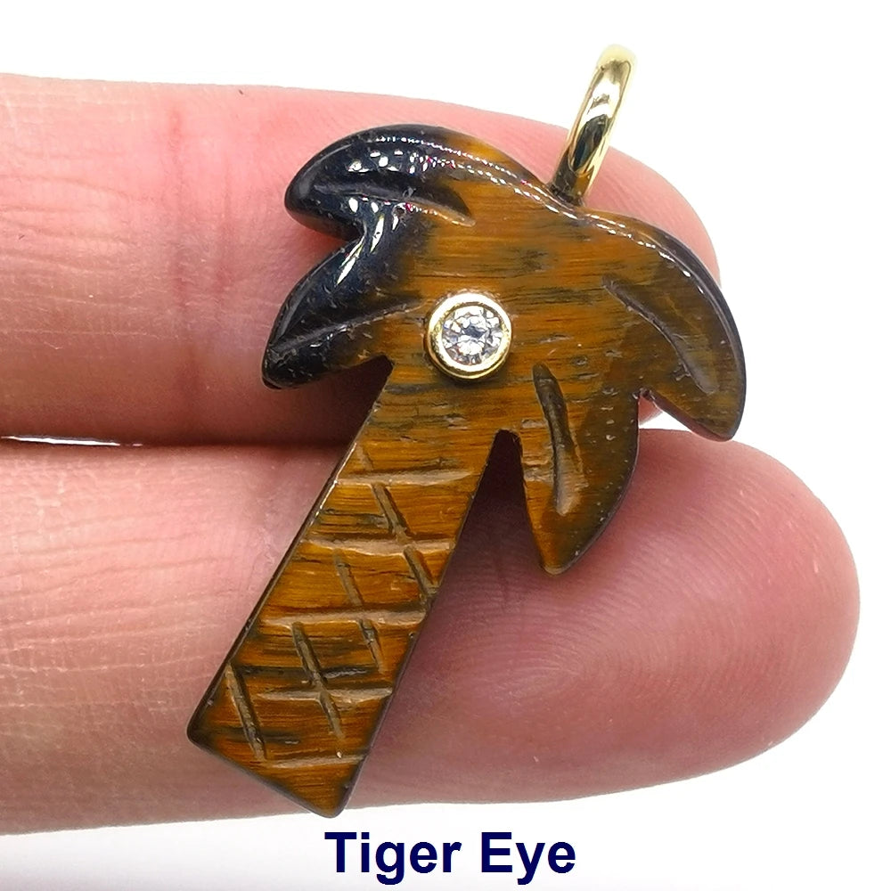 A natural crystal tiger eye pendant with a zircon charm is held by a hand.