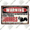 A vintage metal warning sign with red lettering that reads Warning This property is protected by highly trained squirrels.