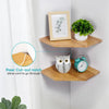 Two natural wood wall-mounted corner shelves displaying a potted plant and an owl clock.